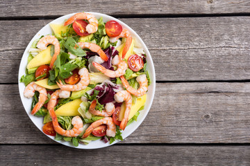 Mix of salad with shrimps , avocado and cherry tomatoes . Healthy food background