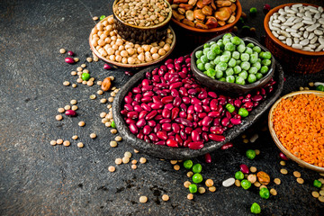 Various assortment of legumes - beans, soy beans, chickpeas, lentils, green peas. Healthy eating concept. Vegetable proteins. White marble background copy space top view