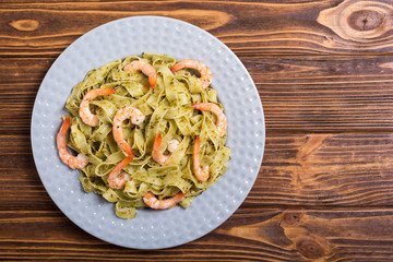 Pasta tagliatelle with sauce pesto and shrimps . Italian food background