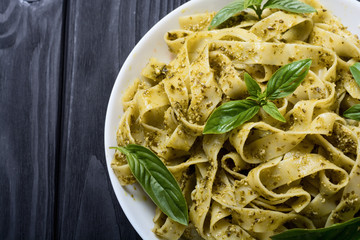 Pasta tagliatelle with green sauce pesto . Italian food background