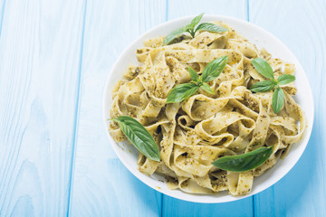 Pasta tagliatelle with green sauce pesto . Italian food background