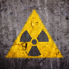 Radioactive (atomic ionizing radiation) danger warning symbol in triangular yellow shape painted on...