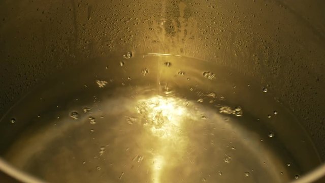 Growing distillery for the production of plum brandy by firing in a gas boiler, alembic pot still during process of distillation flow fresh plum brandy, bottles plum liquor slivovitz traditional czech