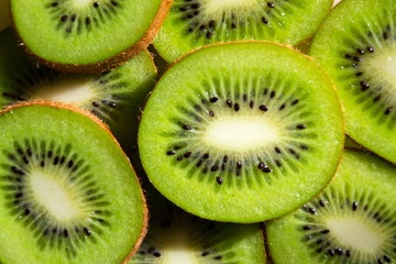 Sliced green fresh kiwi fruit pieces lying on table, flat lay view, healthy diet © josefkubes