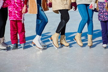 Close-up of the skates from the skaters on the ice surface. Skate on the ice in the company of friends. Skate rental.  place for text