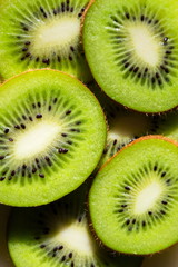 Sliced green fresh kiwi fruit pieces lying on table, flat lay view, healthy diet