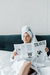 beautiful girl reading travel newspaper on bed