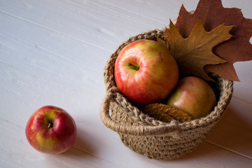 Red apples in a basket on a table.