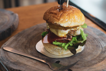 Hamburger on wooden cutting board.