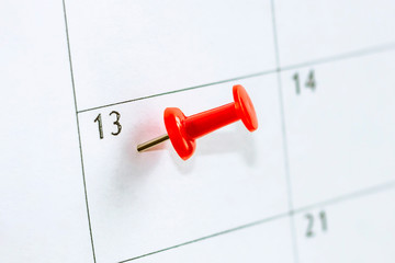 close up 13 date on calendar marked with red thumbtack. Save the Date concept.