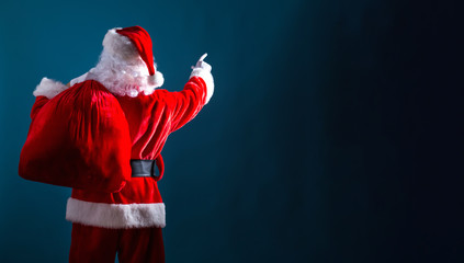 Santa pointing at the sky on a dark blue background