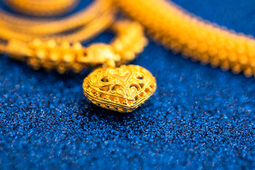 heart shape art of gold ornament on glitter blue copy space background