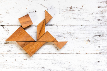 Tangram puzzle in falling man shape on old white wood background (Concept for business crisis)