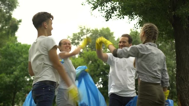 Family of enthusiasts doing voluntary Saturday work, picking garbage in park