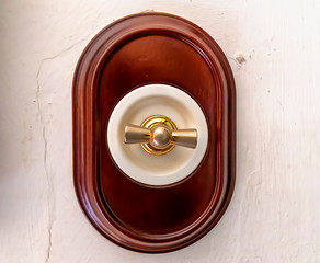 old and luxury rotary electrical switch mounted in a lime wall