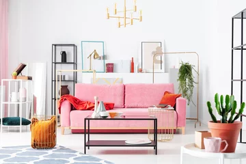 Gardinen Farbenfroh Real photo of colorful living room interior with a velvet sofa, coffee table and shelves with decorations  © Photographee.eu