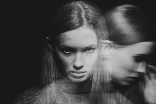 Back and white multiple exposure of beautiful young woman with mood disorder