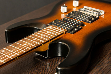 Electric guitar with six strings. Wooden table.