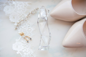 beautiful wedding accessories. Bride shoes, perfumes on a white veil.