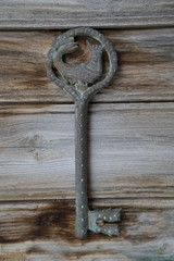 Antique key with the figure of Shahmaran (Queen of Snakes) on vintage wooden.