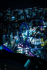 Tokyo night view with light trails of a ferris wheel in an amusement park, shot from an observation deck in Bunkyo district