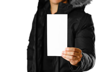 A man in a warm winter jacket holding a white leaflet. Blank paper. Close up. Isolated on white background