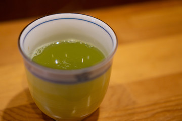 Hot green tea in ceramic cup in Japanese restaurant