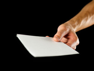 Hand holding blank brochure booklet in the hand. Isolated on black background. Man show offset...