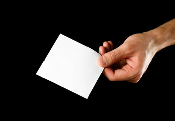 Obraz premium Hand holding blank brochure booklet in the hand. Isolated on black background. Man show offset paper. Sheet template. Book in hands. Booklet folding design. Fold paper sheet display read