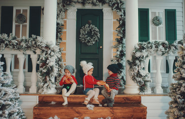 A portrait of children sitting on the porch of their house together, Eat bagels. Merry Christmas,...