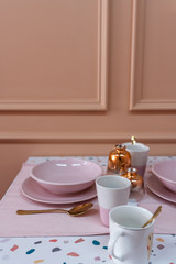 Dining corner with terrazzo top table and baby pink chair and decoration prop on the table with old rose painted wall on the background / interior design concept / studio shot