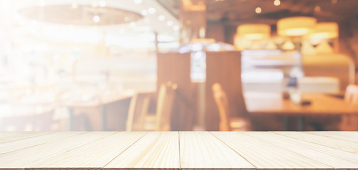 Wood table top with Restaurant cafe or coffee shop interior with people abstract defocused blur background