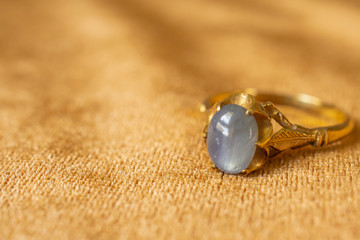 Vintage gold Jewelry blue sapphire ring on fabric texture