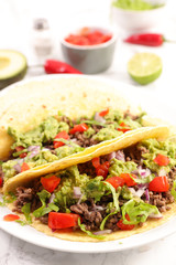 taco with beef, avocado and tomato