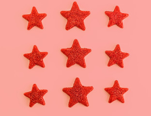 Fototapeta na wymiar Nine red stars on pink background. Flat lay. View from above