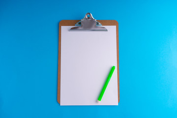 Clipboard and pencil on blue background with selective focus and crop fragment