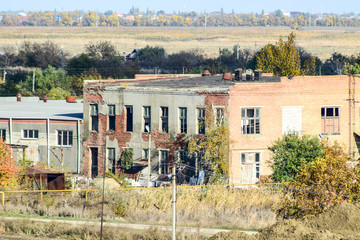 Obraz premium Old abandoned buildings of the former factory and warehouses. The destroyed essential oil plant. Soviet heritage. Old brick buildings. Settlement in the Kuban