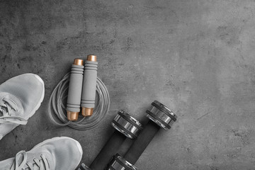Flat lay composition with jump rope, gym equipment and space for text on grey background