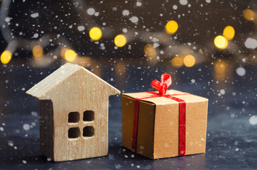 Wooden house and present. Christmas Sale of Real Estate. New Year discounts for buying house. Purchase apartments at a low price. Winter resort and vacation. Holiday discounts