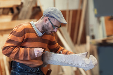 Carpenter working on wooden forcola for venetian gondola