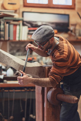 Carpenter working on wooden forcola for venetian gondola