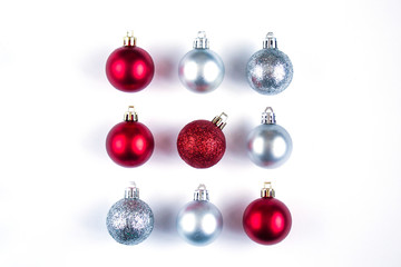 Nine Christmas red and silver balls with shadows on a white background. New Year's composition. square