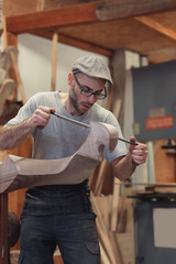 Carpenter working on wooden forcola for venetian gondola © guerrieroale
