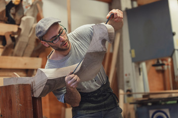 Carpenter working on wooden forcola for venetian gondola