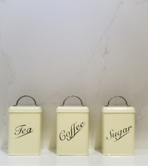 Tea Coffee Sugar tins on a marble worktop and background
