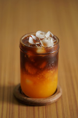 ice black orange a coffee cocktail on wood table.