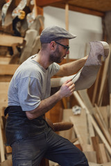 Carpenter working on wooden forcola for venetian gondola