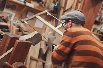 Carpenter sawing wooden detail