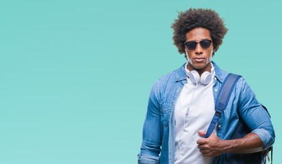 Afro american man wearing headphones and backpack over isolated background with a confident expression on smart face thinking serious