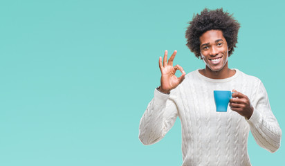 Afro american man drinking cup of coffee over isolated background doing ok sign with fingers, excellent symbol